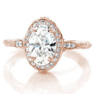 Antique inspired custom engagement ring in Montreal with a unique diamond halo surrounded a oval center diamond.