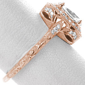 Rose gold engagement ring in Dayton with diamond halo, oval center stone and relief engraving.