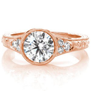 Rose gold custom engagement ring in Toronto with a round brilliant center diamond held in a setting with unique filigree and hand engraving.