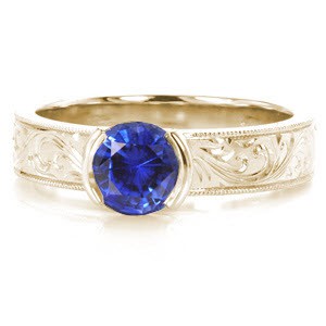 Antique inspired custom engagement ring in Vancouver with scroll hand engraving and a round blue sapphire center stone.