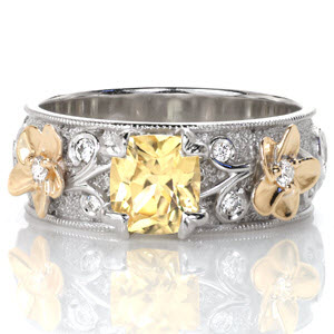 With a distinctive feminine style and wider 14k white gold band presence, Design 3295 displays a 1.15 carat yellow sapphire within four petal prongs. Dimensional elements of 14k yellow gold flowers and hand formed stippling background provide contrast, making the different colors pop within the design.