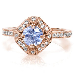 Custom antique inspired rose gold engagement ring in Raleigh featuring a round light blue sapphire held in a unique halo setting.