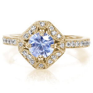 Custom antique inspired engagement ring in Hartford featuring a round light blue sapphire held in a unique halo setting.