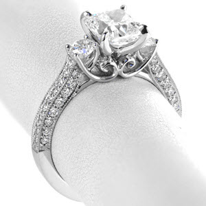 Unique three stone engagement rings in Indianapolis with filigree and a three sided micro pave band. This dazzling ring is set with an array of brilliant diamonds. The sides of the ring feature vintage filigree details on the sides of the center stone setting.