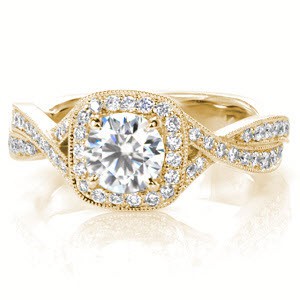Custom engagement ring in Stamford with a cushion cut center stone surrounded by a bead set diamond halo and twisting band.