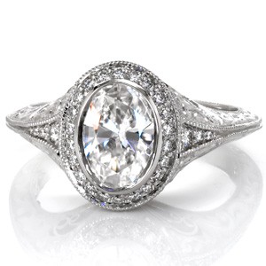 Custom antique inspired engagement ring with an oval cut diamond center surrounded by a diamond halo and a knife edge engraved band in Dayton.