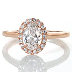 Rose gold halo engagement ring in Tampa features an elegant, high-polished rose gold band with a dazzling rose gold and diamond halo. The oval center diamond is surrounded by an oval halo. 