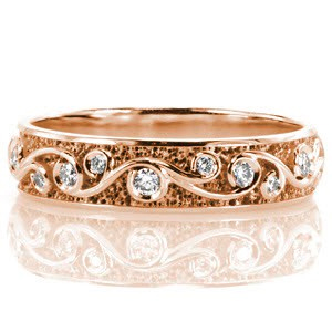 Custom rose gold wedding ring in Baltimore with a scroll pattern highlighted by bezel set diamonds.