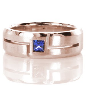 Modern lines and contrasting finishes highlight a natural blue sapphire in Design 3354. Crafted in 14k white gold, a square cut natural blue sapphire is outlined with bold open-cut grooves. The hand-applied brushed finish and high polish beveled edges bring balance to this wider band.