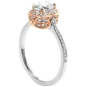 Rose gold oval engagement ring in Calgary features an oval center stone with an oval halo. The micro pave band is shown in white gold  leading up to an intricately detailed rose gold antique halo. 