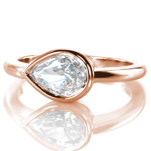 Design 3367 is an adventurous solitaire engagement ring featuring a 0.70 carat pear cut diamond tiled from its classic vertical positioning into a modern west-to-east interpretation. The ring design is finished with a full bezel diamond setting and an elegant high polished band.
