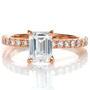 Gorgeous micro pave rose gold engagement ring in Atlanta. The emerald cut center stone lends a vintage appeal to this classic diamond and rose gold engagement ring design.