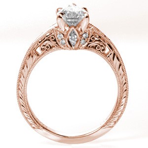 Rose gold custom engagement ring in Dallas with a unique pear cut center diamond held on a band featuring bead set diamonds and hand engraving.
