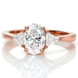 Design 3376 is a modern update on a classic three stone design. The 1.20 carat oval center diamond is beautifully nestled between two brilliant trillion cut diamonds. The band tapers as it reaches the trillions to blend seamlessly into the points; creating an elegant, geometric piece.