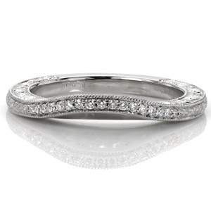 This delicate wedding band was designed to wear against our Design 3248. The band slightly contours to follow the shape of the engagement ring for a perfect fit. Bead set diamonds and floral engraving runs the length of the band top view, with scroll relief engraving and filigree shown on its profile.