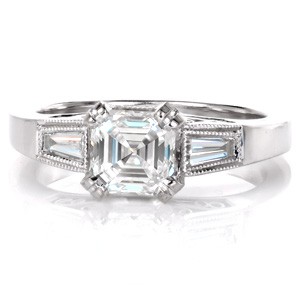 Design 3385 is a stunning blend of geometric shapes and antique inspiration. The long linear facets of the asscher cut is mirrored in the baguette side stones. The band flares to the top of the ring where tapered baguettes are bezel set. Platinum filigree curls adorn the sides of the ring for a vintage appeal. 