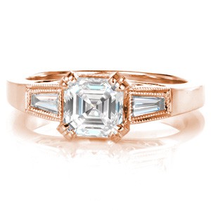 Rose gold custom engagement ring in Vancouver with an asscher cut center diamond held by diamond set prongs and profile filigree curls.