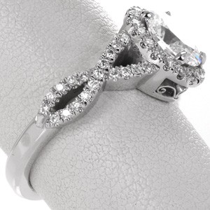 Unique diamond halo engagement ring in San Antonio. This infinity band engagement ring features woven diamond bands with an oval shaped diamond halo. The basket under the halo is detailed with vintage style hand formed filigree curls. 