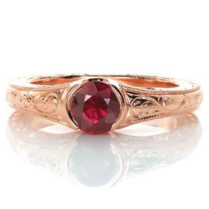 Design 3437 is a gorgeous example of a custom solitaire engagement ring featuring a unique gemstone center. The vibrancy of the 0.70 carat round ruby is complimented by warm rose gold. Intricate hand engraving, filigree and milgrain edging make this design a one-of-a-kind vintage inspired custom ring. 