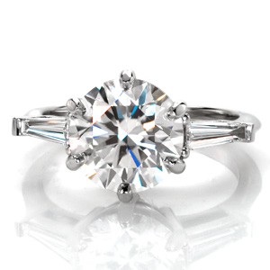 Design 3447 is a contemporary twist on a vintage classic. This three stone diamond engagement ring design features a long, elegant, tapered baguette on each side with a large center stone. The 2.50 carat round brilliant diamond center is held in a six prong setting for a nod to the original antique inspiration.