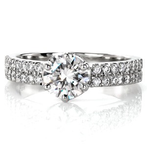 For a regal diamond engagement ring look no farther than Design 3453. The double row  micro pavé diamond band leads to a crown inspired center setting. The diamond drapes of the basket are edged in milgrain. The round brilliant cut center diamond is held in a six prong setting for an antique tribute.