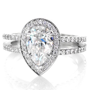 For a beautiful split shank design with a unique center, consider Design 3454 as shown with a pear cut center stone. This 1.30 carat pear diamond is held in a five prong setting above a diamond halo. The halo is edged in milgrain texture to frame the center stone and highlight its brilliance.