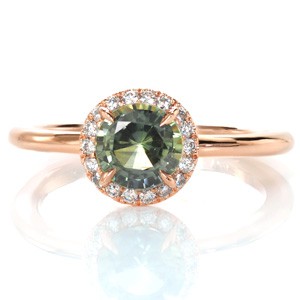 Unique rose gold and green sapphire halo engagement ring in Portland. High polished rose gold band adds luster to the sparkle of the diamond halo. 