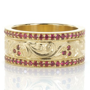 Our Design 3468 took inspiration from another of our custom creations and re-imaged this intricate band in gorgeous color. The wide band ring features hand engraving in a scroll pattern, scattered with floral shaped bead set rubies. Vibrant rubies also frame with central design in bead set rails. 