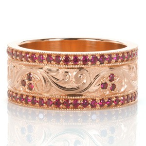 Our Design 3468 took inspiration from another of our custom creations and re-imaged this intricate band in gorgeous color. The wide band ring features hand engraving in a scroll pattern, scattered with floral shaped bead set rubies. Vibrant rubies also frame with central design in bead set rails. 