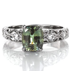 Design 3473 connects a heritage expression along with on-trend hues of a 2.00 carat cushion cut green sapphire flawlessly.  The openwork band creates a unique appearance by contrasting high polish 14k white gold with airy band openings and hand applied milgrain detail. 