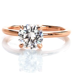 A refined beauty, our Petite engagement ring design is a classic solitaire setting updated in vivid rose gold. A 1.20 carat round diamond is held at the center in a low-set four prong setting. A slim rounded band finishes this minimalist solitaire design. 
