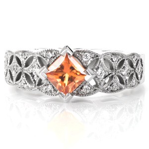 Design 3486 will take your love out of this world with an intricate, star burst patterned,  micro pavé band. The center stone is shown as a rare, .70 carat princess cut orange sapphire. This fiery colored sapphire is a lush focal point for this dazzling engagement ring design.