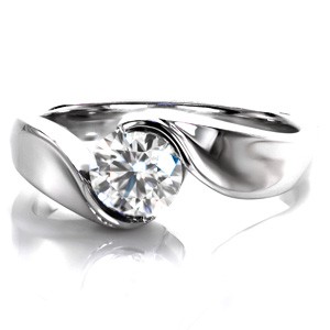 This beautiful Yin-Yang setting features a round brilliant cut diamond as a solitaire. The metal appears to flow up the band like water to wrap around the center stone. The different surfaces are all high polished and the luster of the metal is a perfect compliment to the dazzling sparkle of the diamond.