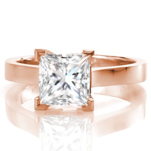 Clean, modern lines are the hallmark of this design. A stately 2.5 carat princess cut diamond is held securely in four chevron prongs, adding visual appeal and protection to the diamond's corners. The high polished, square shaped band contours up slightly to meet the center setting. 