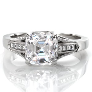 This stunning engagement ring design was inspired by the beauty and romance of Paris, France. An asscher cut diamond is set between dazzling, channel set, carre cut side diamonds while milgrain beading frames the design. The sides feature beautiful hand formed filigree curls and an elegant center setting style.