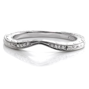 This delicate matching band is created to perfectly fit the curves of the Seville engagement ring. The contour of the wedding band tapers at the middle of the center diamond to minimize the outside curves. Accented with small round diamonds and exquisite hand engraving details, this band is an elegant addition.