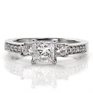 Royal Princess Three Stone is a classic design with a contemporary twist. The 0.50 carat princess cut is flanked on each side by similar square shaped stones. The band is accented with five bead-set round brilliant diamonds and milgrain texture to enhance the beauty of the three stone design. 