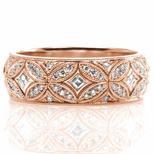 Design 3516 conveys elegance with its curving lines and intricate interlocking pattern. This wide, half-round band features bezel set carre cut diamonds surrounded by mosaic-like sections of bead set side diamonds. Milgrain edging adds the final vintage inspired touch to this exquisite custom ring. 