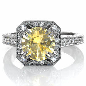 Design 3520 features a stunning 2 carat yellow sapphire to redefine one of our most popular settings. The center stone is surrounded by a scalloped diamond halo and vintage inspired milgrain edging. Hand carved relief engraving adds elegance to the profile view.  Micro pavé and milgrain add sparkle to the band. 