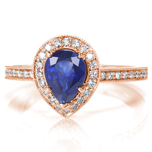 Alluring with a lush blue sapphire center stone, Design 3564 is shown with a pear shaped micro pavé halo. The diamond apron around the sides of the halo and the cathedral style band are also adorned with micro pavé diamonds. This engagement ring is designed to easily sit flush with a wedding band.