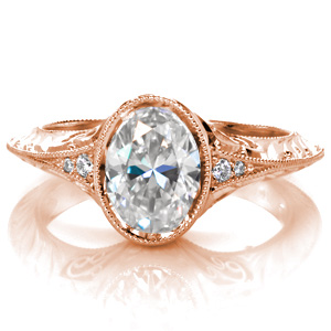 Shown with a 1.00 carat oval center diamond in a bezel setting, the Oval Marseille features an antique style knife-edge band. Small micro pavé diamonds add a hint of sparkle to the top and sides of the piece, while hand wrought filigree curls and hand engraved patterns provide the perfect vintage details.