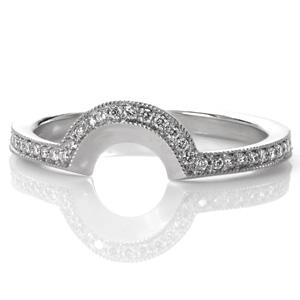This antique inspired wedding band was originally designed as a matching contoured band for Design 3032. The low profile of the curve allows it to tuck in under the detailed basket of the engagement ring. The beadset micro pavé diamonds edged with beaded milgrain texture perfectly match the vintage styling.