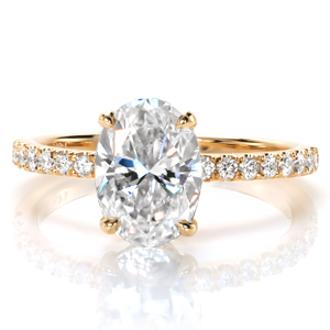 This classic micro pavé engagement ring style is shown with an oval center diamond, and was originally crafted in yellow gold. The warm, rich hue of the metal contrasts with the white of the stones adding an antique feel to the design. A decorative diamond basket has this design sparkling from every angle.