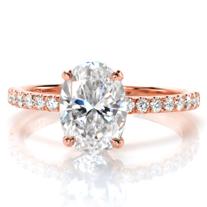 This classic micro pavé engagement ring style is shown with an oval center diamond, and was originally crafted in yellow gold. The warm, rich hue of the metal contrasts with the white of the stones adding an antique feel to the design. A decorative diamond basket has this design sparkling from every angle.