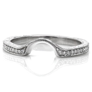 Design 3585 is a beautiful custom contoured wedding band with vintage inspirations. The band is set with micro pavé diamonds to the start of the contour. Exquisite hand engraved scroll engraving has been added to the sides and outer face of the band. Beaded milgrain texture adorns the edges. 