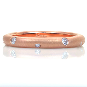 Sparkling like stars, small flush set diamonds alternate in size as they dance around this contemporary band. The contrast between the dazzling gems and the luster of the matte sandblasted finish highlights the complimentary pairing with a feeling of modern elegance.
