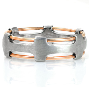 Optio is a modern wedding band shown featured in a two-tone construction. This geometric piece creates a mesmerizing pattern with its seamlessly crafted multi-piece design, open metal work, and the contrast of high polished rose gold wires and brushed 14k white gold framework.