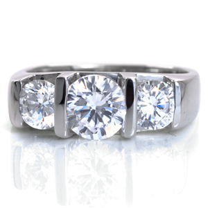 Bliss is a perfect representation of contemporary beauty. This modern engagement ring design is shown featuring a half-bezel set 1.00 carat round brilliant cut center stone framed with 0.50 carat side diamonds. The wide band is wide for an added sense of strength. The Euro-shank base mimics the top shape of the band.