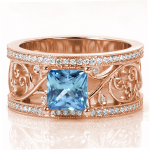 This breathtaking design features a large, open filigree pattern set with small diamonds in some of the curls. The micro pavé diamond rails are edged in milgrain for added vintage appeal. Shown here with a unique 1.70 carat princess cut sapphire, Design 3598 is a statement piece.