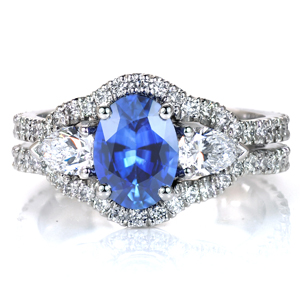 Featuring a luscious oval sapphire center stone, Design 3600 is a unique take on a triple halo design. The micro pavé diamond band flows up and flares out to contour around the trio of center stones. A pair of pear cut diamonds flank the sapphire center stone with dazzling beauty.